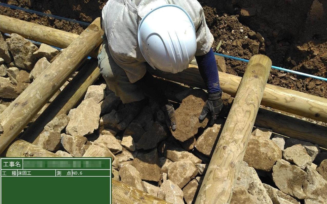 平らな面を上に合わせて石を詰めているところ